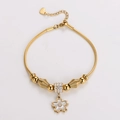 Detalle de pulsera dorada con dije de flor y cuentas de cristal en cadena de serpiente - Dorado