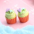 Macro shot of two resin cupcakes with colorful hearts and stars on a pink background - Star & Heart Cupcake - Orange Base