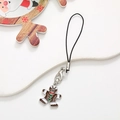 Detailed view of gingerbread man phone charm with brown enamel and red bow decoration - Gingerbread Man / Silver