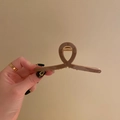 Hand holding a twisted brown hair claw clip with a glossy finish and gold metal spring - Large 11.5cm / Coffee