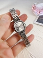 Close-up of square silver watch dial with five-link metal strap and protective film - Silver White Dial
