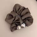 Brown silk scrunchie featuring a metal heart charm and pearl detail on leather texture - Mocha Heart Crystal
