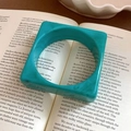Vintage style square turquoise resin bangle with marble texture on an open book - Turquoise Cloud