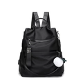 Mochila de nailon negro con bolsillo frontal y pompón blanco sobre fondo blanco puro - Negro