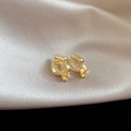 Close-up of golden clip-on earring converters with soft silicone pads on silk fabric - Round Ear Clip Converter / Gold