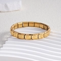 Macro shot of gold stainless steel elastic bracelet links with paw print patterns - Style BD-162 / All Gold Paw / 9mm
