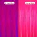 Neon rose pink tinsel curtain showing UV glow effect versus normal light comparison - Tinsel Curtain / Fluorescent Rose Red