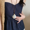 Close-up of bohemian shell necklace with wood bead on a model in sunlight - 26# Necklace - Brown - Scallop