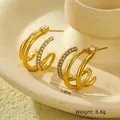 Macro-opname van 18K vergulde driedubbele oorringen met micro-gezette zirkonia accenten - 18K goud / Goud