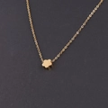 Gros plan d'un pendentif fleur dorée minimaliste sur une chaîne à maillons fins et polis - Or