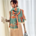 Thick cyan and orange scarf with carriage pattern and tassels shown on a model - Carriage Years-Green