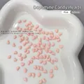 4x5mm Nude Pink resin heart charms for nail art and DIY displayed on a ceramic tray - 100 Pieces Set / Nude Pink