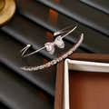 Detail of silver double-layer bracelet featuring zircon butterfly and heart-shaped stones - Silver