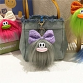 Dettaglio di portachiavi mostro in peluche grigio con fiocco su borsa di jeans - Grigio