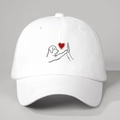 Dettaglio del cappellino bianco con illustrazione minimalista di un cucciolo e cuore - Taglia unica / Bianco