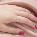 Dettaglio di un anello dorato con zirconi e perla su uno sfondo di seta rosa - Oro / Stile Forma T (SE880)