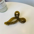 Detail of olive green translucent bow hair claw clip on a minimalist white table - Jelly Yellow Green