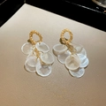 Vista detallada de pendientes dorados con colgantes de concha sobre fondo de cuero beige - Pin de Plata S925 Dorado Blanco Concha
