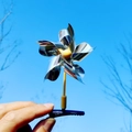 Barrette moulin à vent argentée avec feuilles métalliques et base noire sur ciel bleu - Transparent/Argent