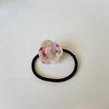 Detailed view of 3D cream camellia flower hair tie with red dots on black elastic band - Pink and White Floral