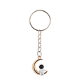 Detail of creative astronaut sitting on a gold moon pendant keychain with silver chain - Moon Spaceman