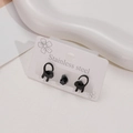 Set of three stainless steel black cat earrings and a round stud on a white background - Black