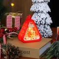 Red Christmas lantern with Santa Claus illustration and warm LED light on wooden desk - Red Santa Claus
