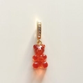 Macro view of red gummy bear pendant with gold diamond-encrusted loop on plain background - Transparent Red