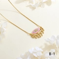 Detailed close-up of pink enamel Evil Eye necklace with leaf tassels on white texture - Pink Tassel Style (NE2255-B-1)