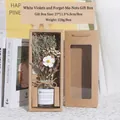 White violet and forget-me-not dried flowers in glass bottle with kraft gift box - Forget-me-not