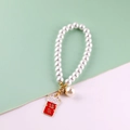 Macro detail of white pearl phone chain with a red Maneki Neko lucky cat charm - Rhinestone Lucky Cat Alloy Pendant