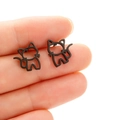 Detailansicht minimalistischer schwarzer Katzen-Ohrstecker auf einer Fingerspitze - Schwarz