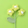 Macro shot of three yellow handmade crochet puff flowers with detailed knit texture - Green