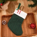 Green cable knit Christmas stocking with embroidered red letter H on a white cuff - Letter H