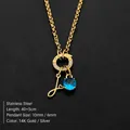 Gold stainless steel necklace with blue gemstone and cursive 'L' letter pendant - Letter J