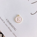 Detalle del colgante redondo letra E de esmalte rosa con borde dorado para joyería DIY - Letra E