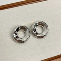 Détail macro de boucles d'oreilles créoles argentées avec finition miroir brillante - Type H Boucles d'Oreilles Miroir Irrégulières Argentées