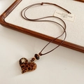 Dettaglio del ciondolo a cuore con motivo leopardato e strass su cordoncino in cuoio - Stile Cuore Stampa Leopardata Marrone