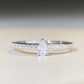Macro shot of S925 sterling silver ring featuring a pear-shaped droplet stone and side diamonds - US 5 / Pear Cut Minimalist-Silver