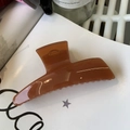 Detailed top view of a large glossy brown hair claw clip showing a thick minimalist resin design - Translucent Dark Orange