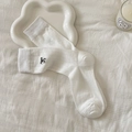 Calcetines blancos de canalé con bordado negro en un fondo suave de estilo minimalista - Blanco