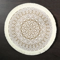 Round beige jute placemat with white mandala pattern and fringe on dark wood background - 38cm / Fringed Everlasting Flower