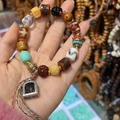 Detailed shot of Tibetan ethnic bead bracelet with Dzi agate, metal pendant and turquoise - Style A: Ox Bone White Crystal Adai Dzi Bracelet