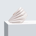 Macro view of a shell-shaped acrylic clutch with pearlescent finish on a white stand - Apricot