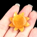 Hand-held orange solar sun stone carving ornament with polished finish and sun-like texture - Topaz