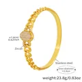 Dettaglio del bracciale in acciaio dorato con maglia NK e decoro centrale in zircone - Zirconia Bianca / Oro