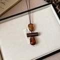 Macro detail of vintage brown and amber beads on a star-shaped wooden pendant necklace - Coffee