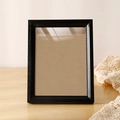 Elegant black rectangle wooden photo frame standing on a light wood tabletop - Obsidian Black Empty Frame / 6 Inch