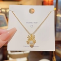 Elegante gouden ketting met strik, witte parel en zirkoon op een merkpresentatiekaart - X315 Strik Parel / Goud