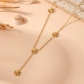 Detail of gold stainless steel Y-necklace with flower charms on pink beach background - Gold Daisy Necklace (H708)